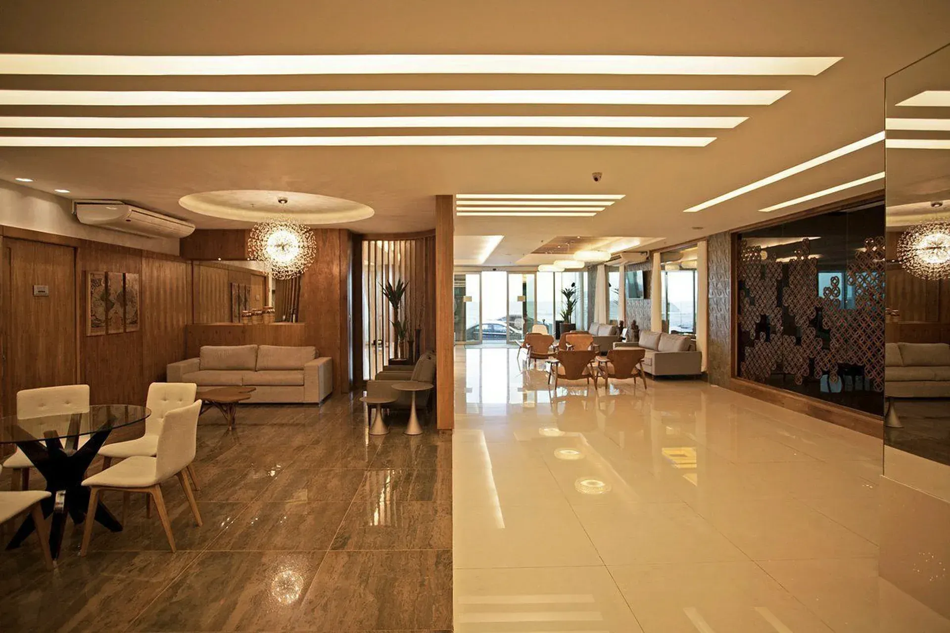 Lobby de hotel moderno com pisos de mármore brilhantes, sofás e iluminação aconchegante.