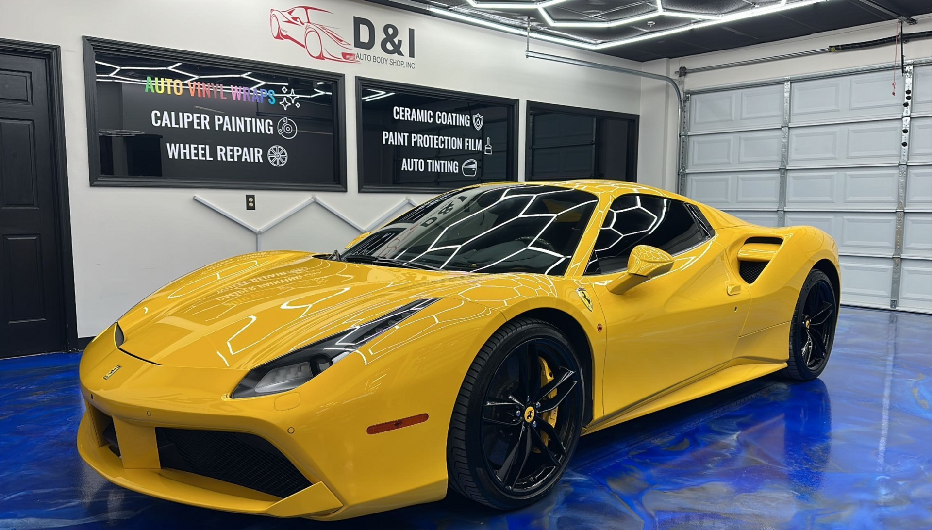Yellow sports car in a garage with blue floor and black wall signs
