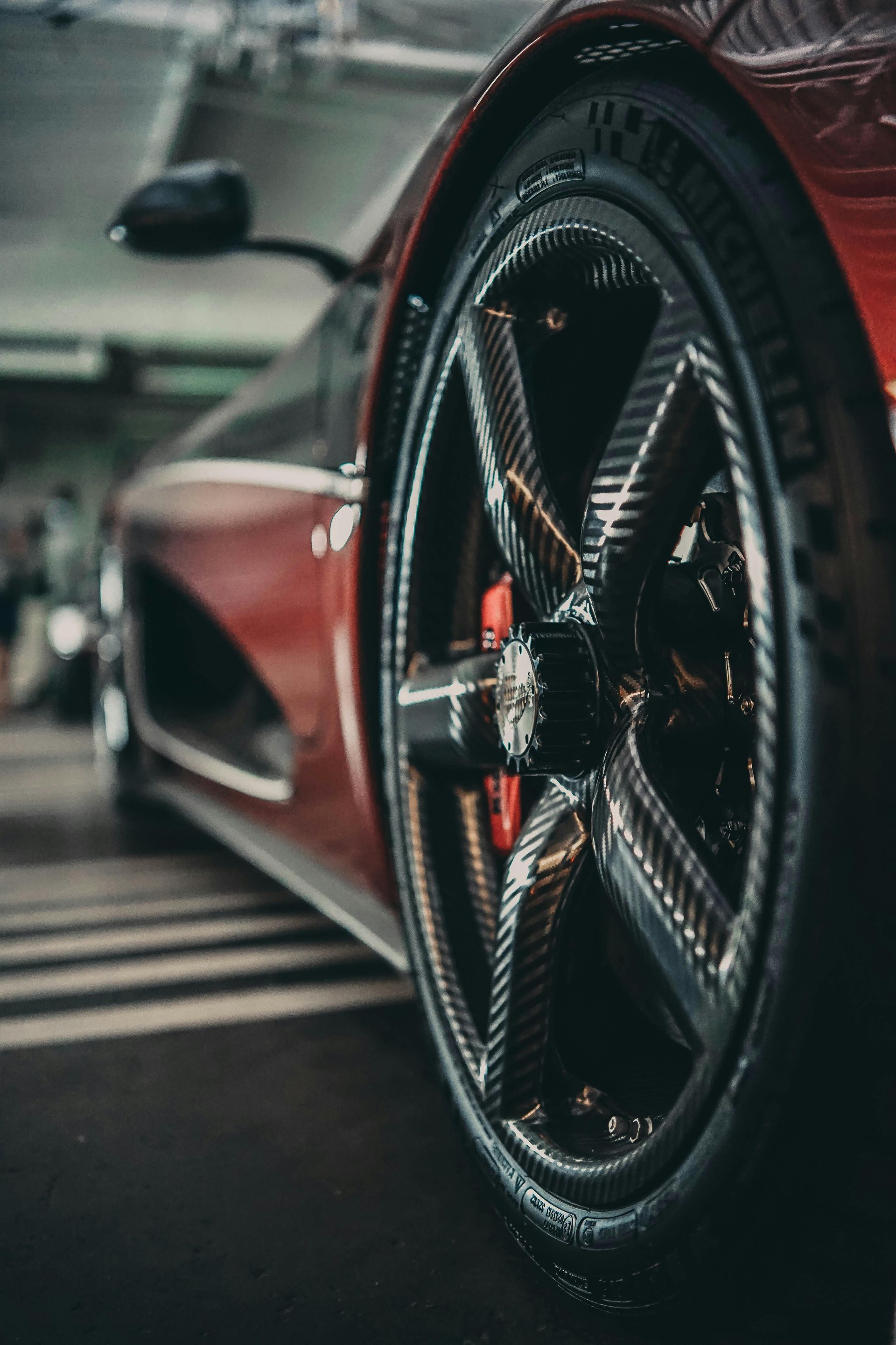 Three Lamborghini sports cars in a garage: black, red, and blue.