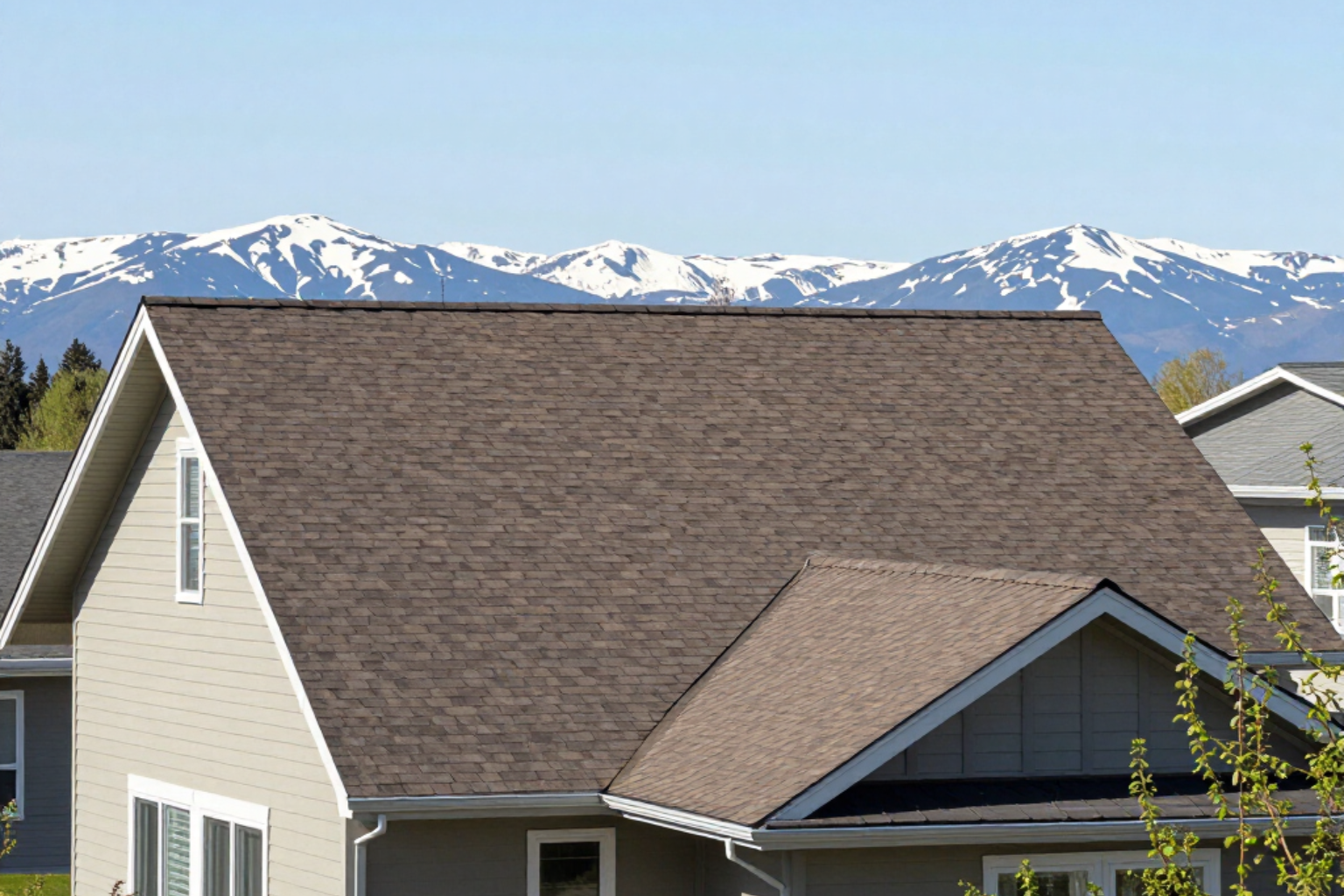 Suburban house roof with snow-capped mountains in the background