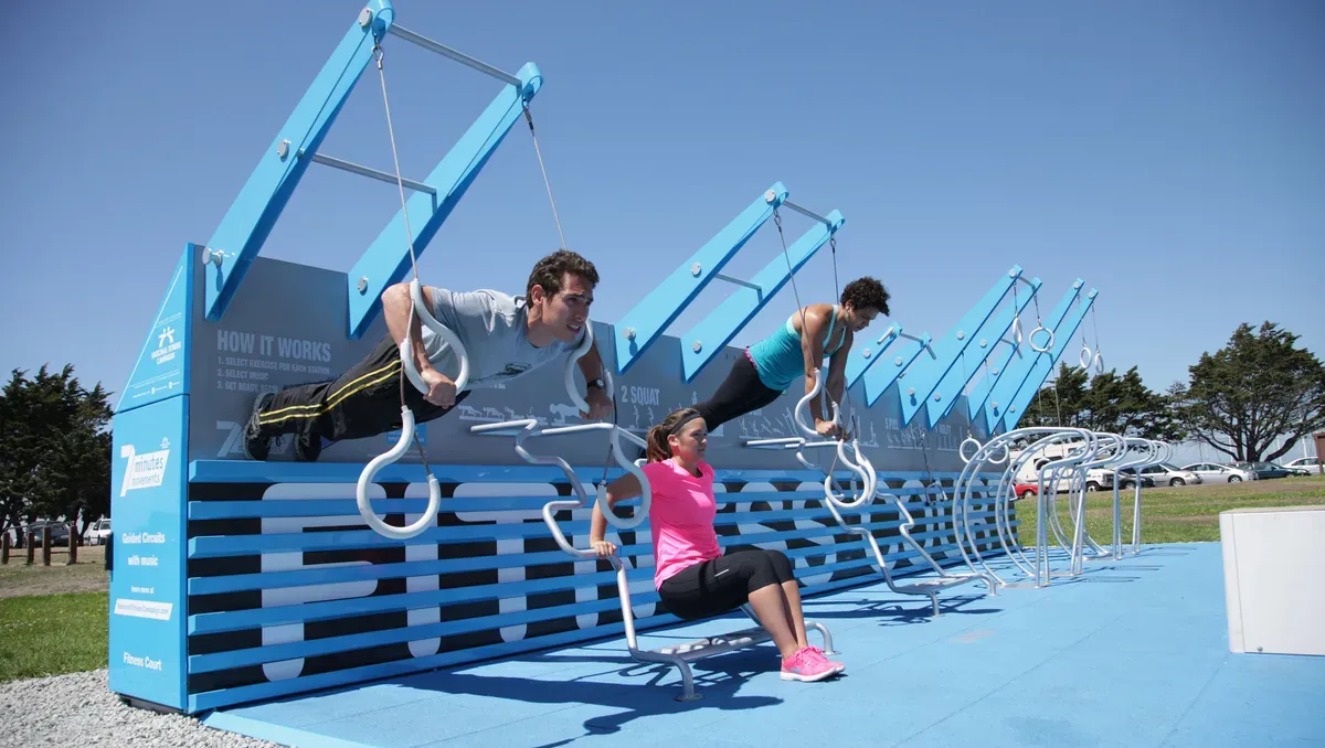 A group of people doing push ups on a blue wall