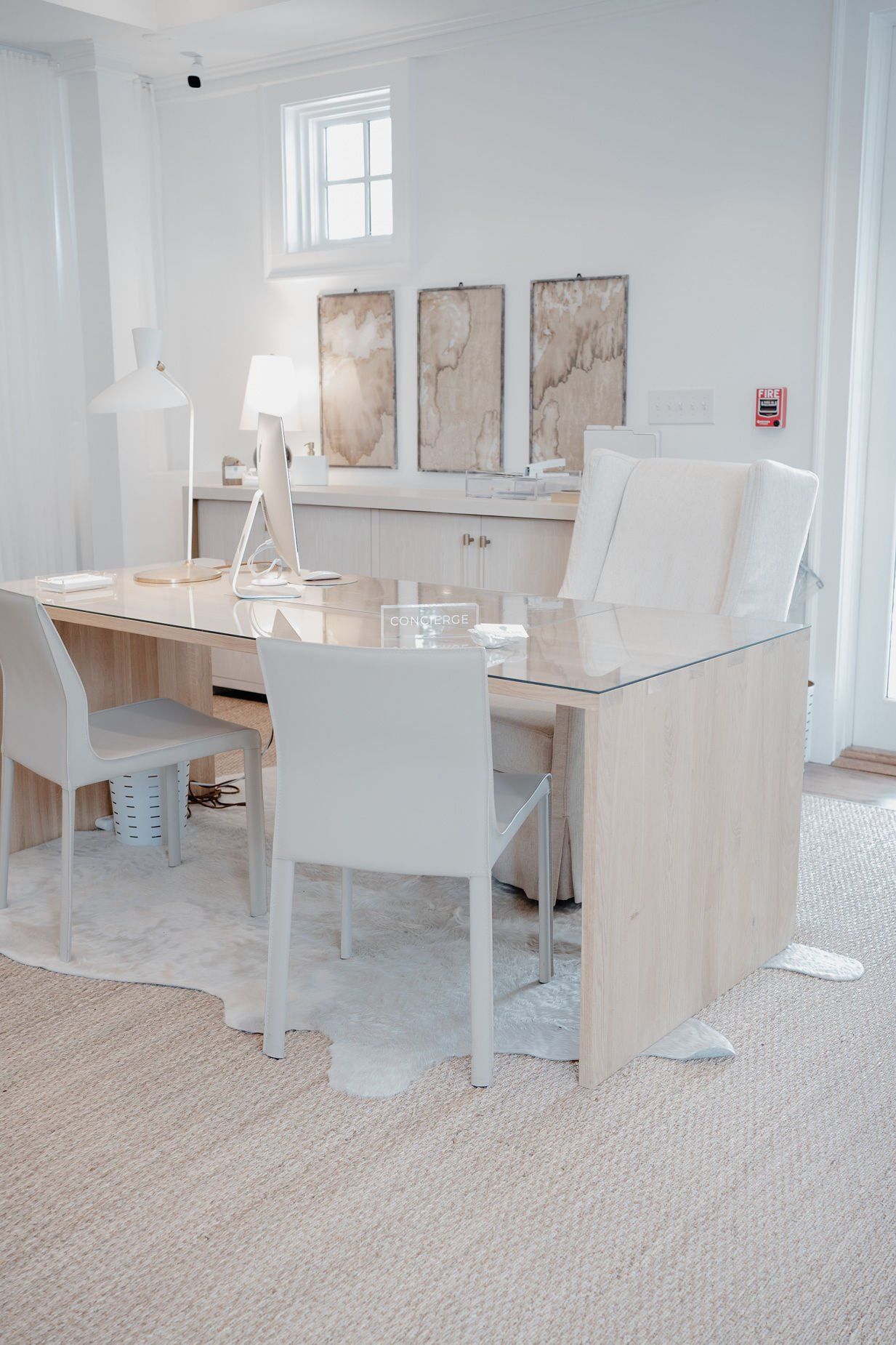 A white room with a desk and chairs in it