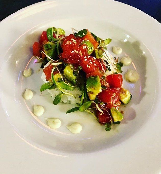 A white plate topped with a salad of vegetables and mayonnaise
