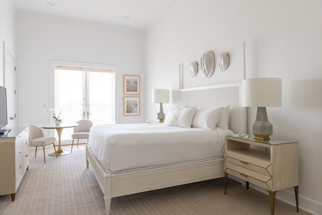 A bedroom with a king size bed , nightstands , lamps and a television.