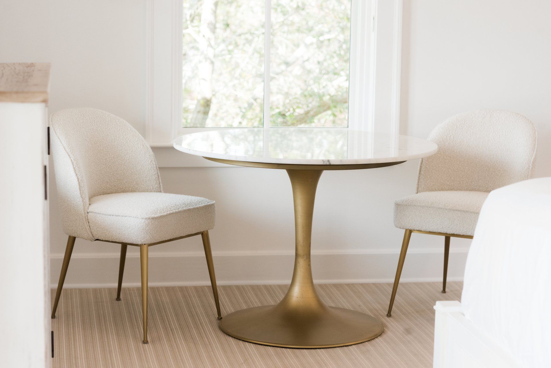 A table with two chairs in front of a window