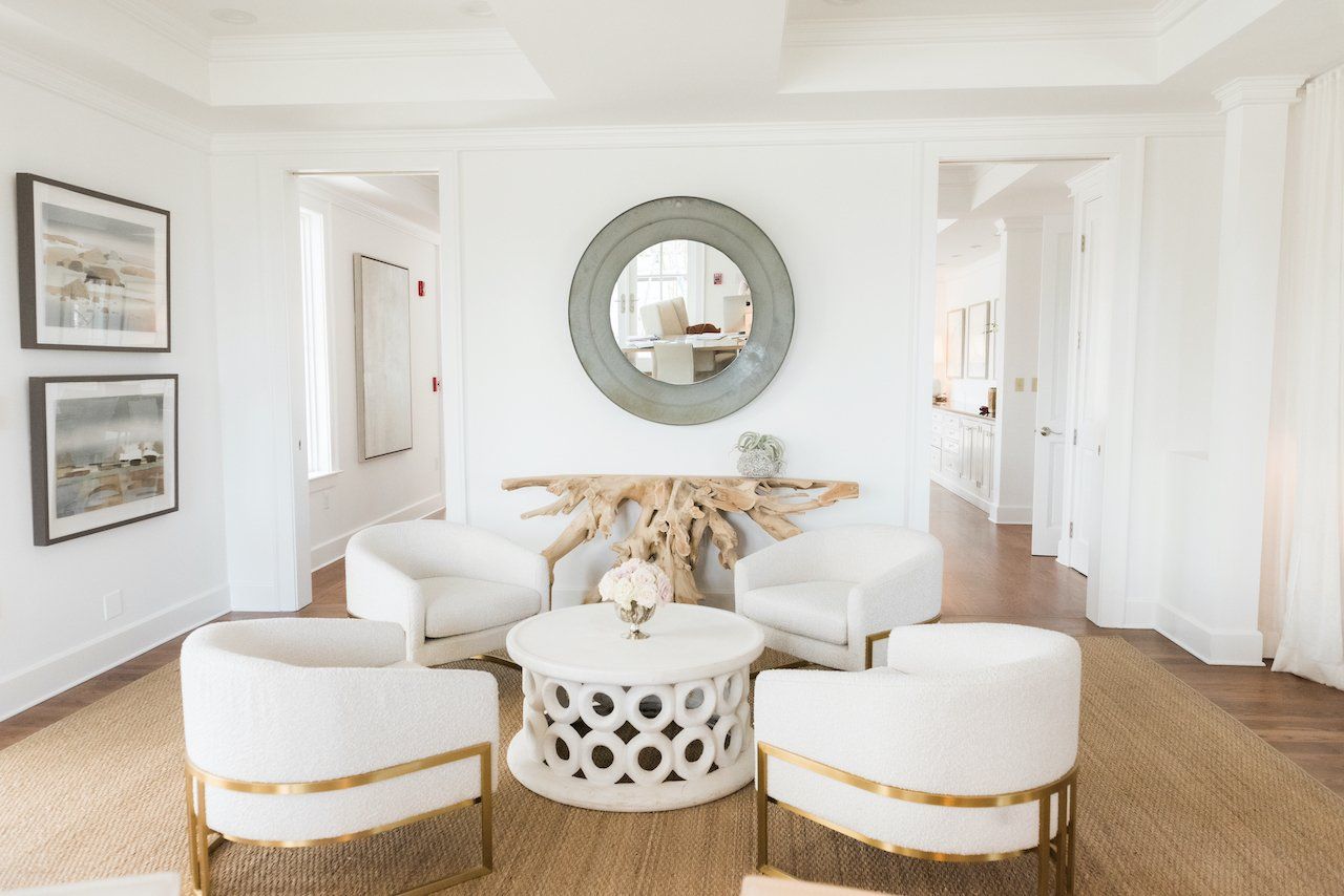 A living room with white chairs and a white coffee table in the lobby of oyster bay boutique hotel 