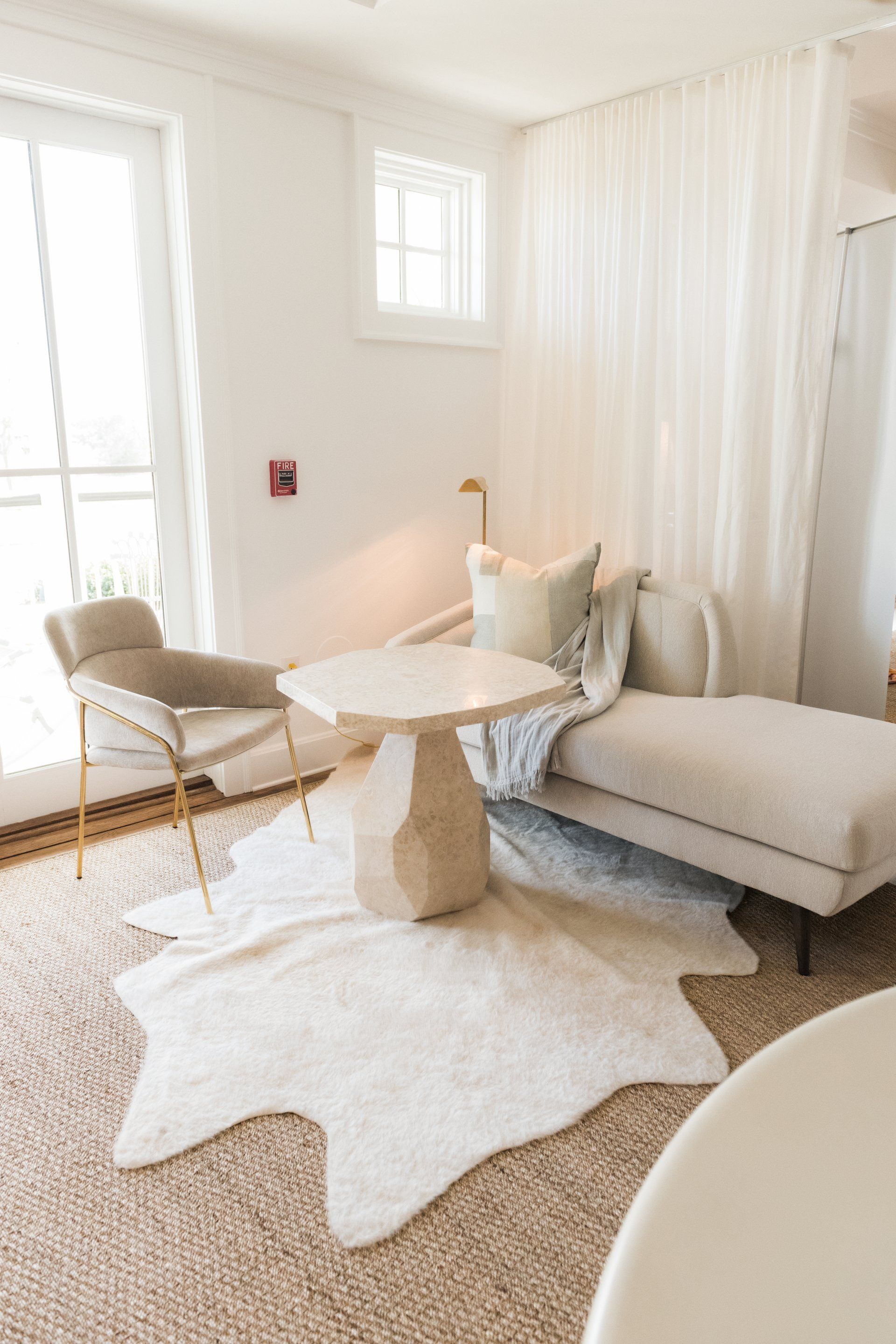 A living room with a chair a table and a rug