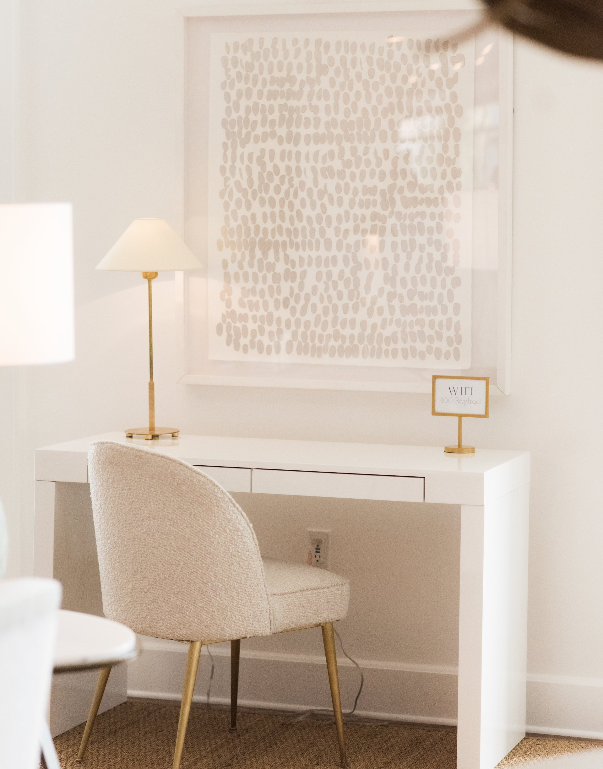 A white desk with a chair and a lamp on it in a room of oyster bay boutique hotel 