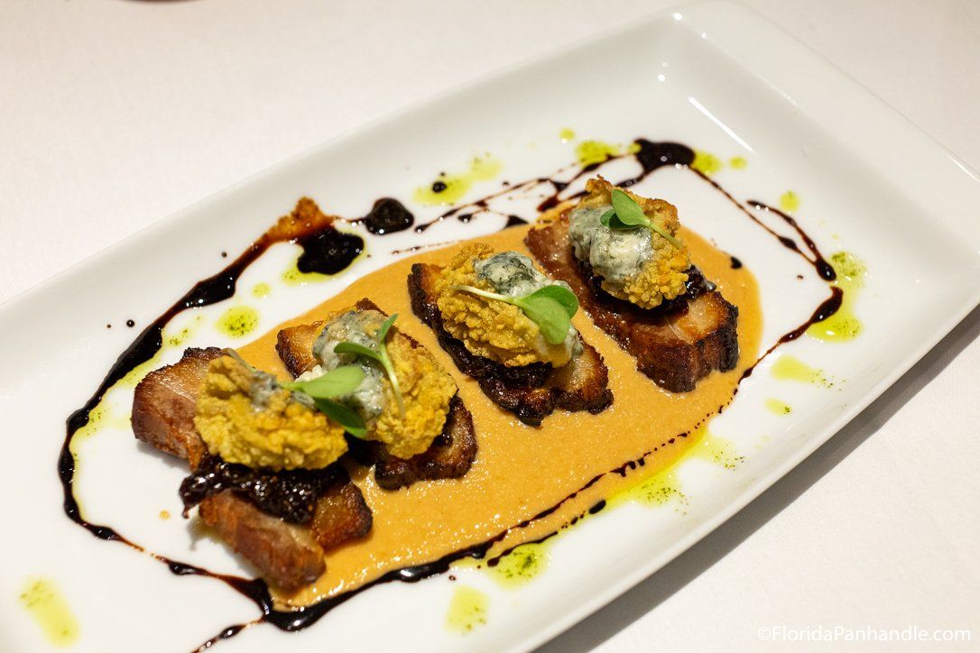 A white plate with a few pieces of food on it