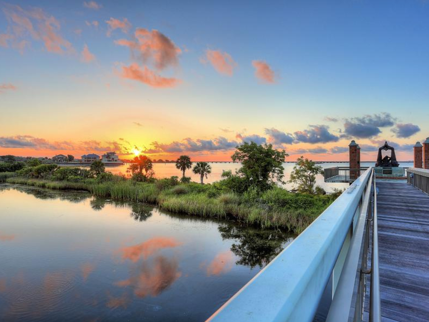 A bridge over pensacola bay with a sunset in the background