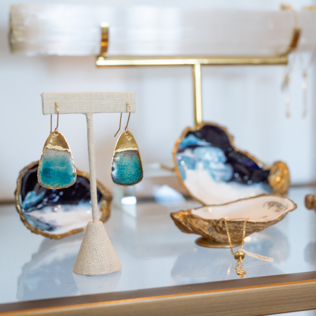 A pair of earrings sitting on top of a glass shelf
