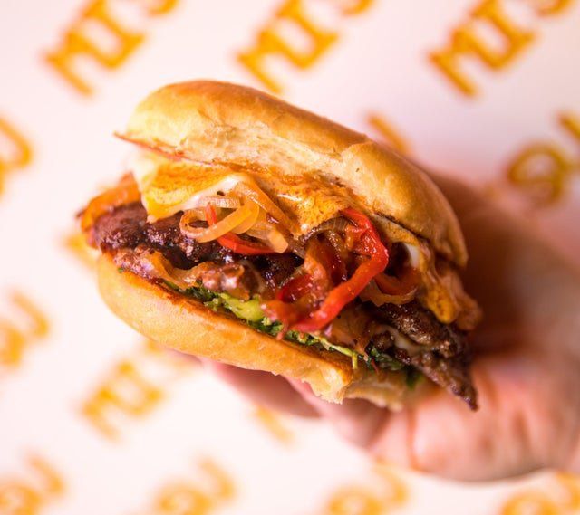 A close up of a person holding a sandwich in their hand