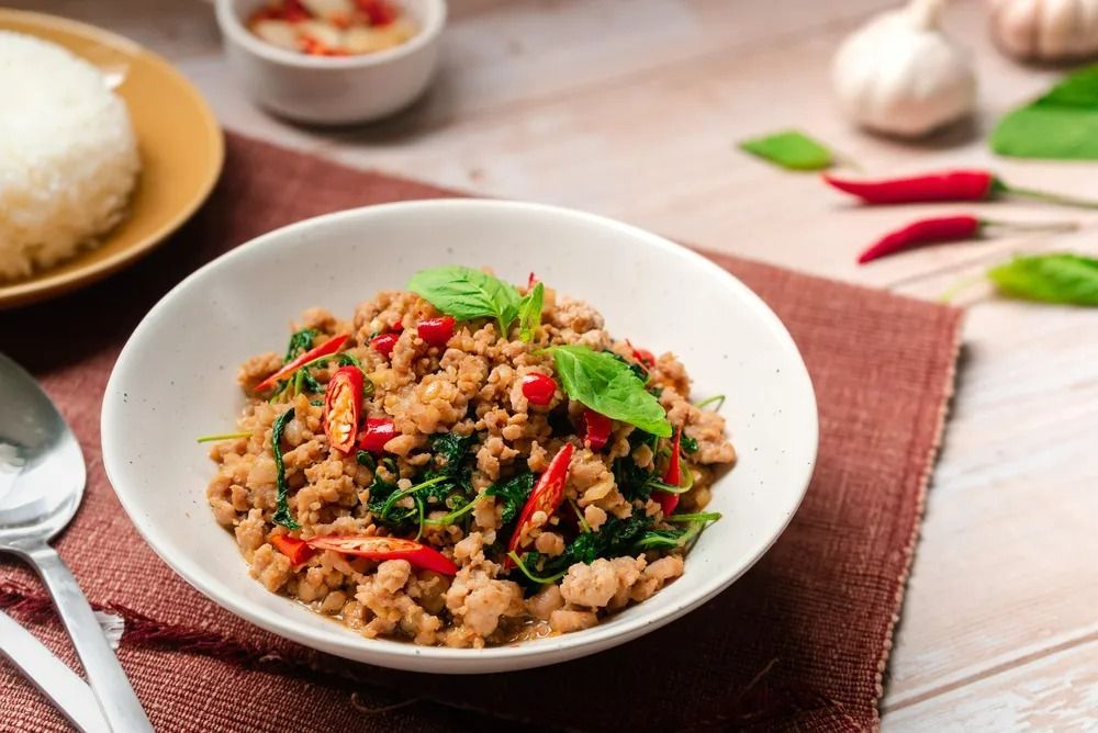 Bowl of Thai Basil Chicken With Rice, Chilies, and Basil Leaves — Thai Taste Restaurant in Norman Gardens, QLD