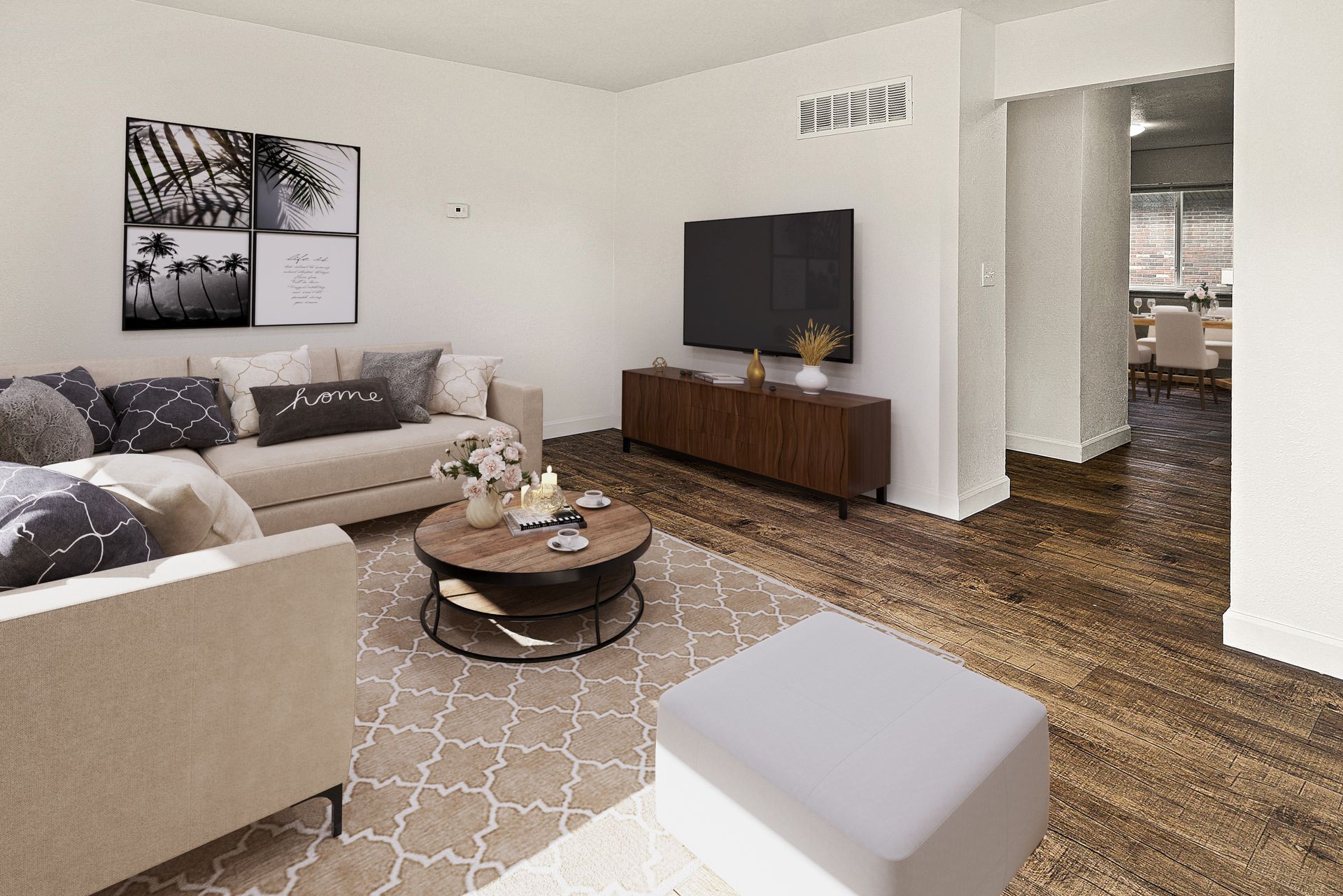 Modern living room with beige sofa, TV on wooden console, round coffee table, and patterned rug