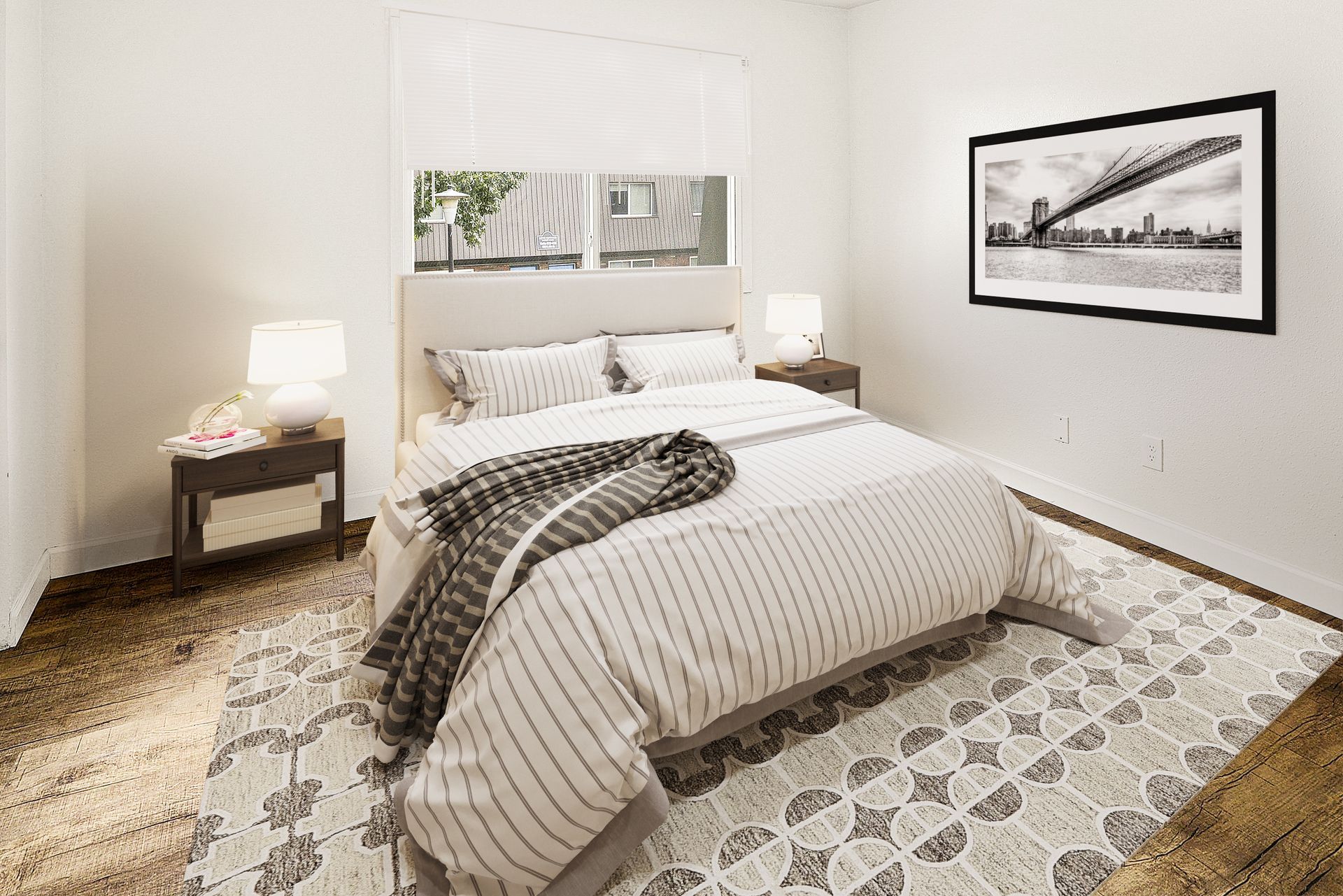 Bright bedroom with a made bed, patterned rug, and framed wall art, lit by bedside lamps