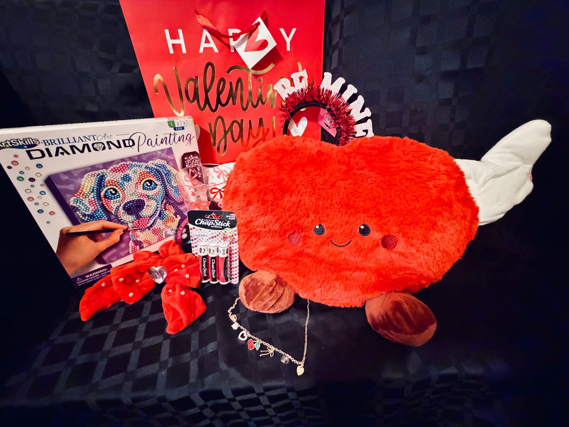 Orange plush toy with white wings beside a Valentine's card and red heart decorations on a dark surface