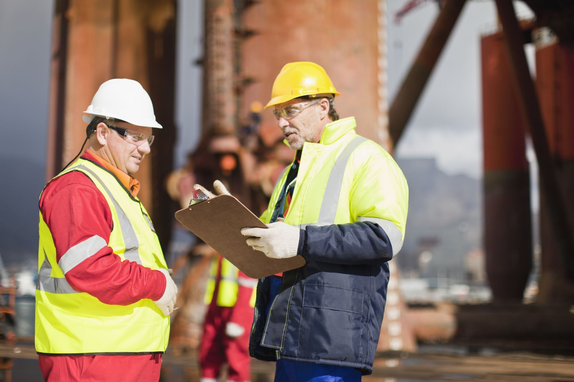 Two construction workers are looking at a clipboard.