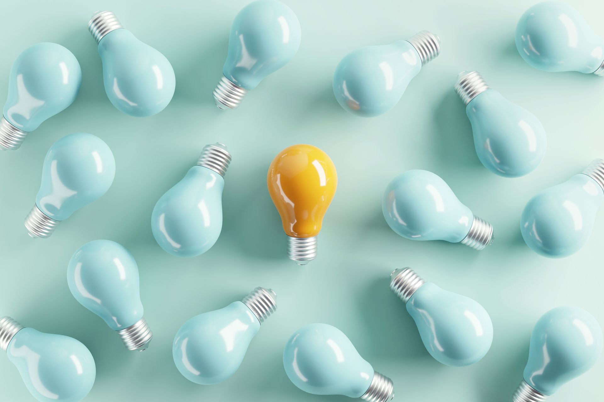 A yellow light bulb is surrounded by blue light bulbs on a blue background.