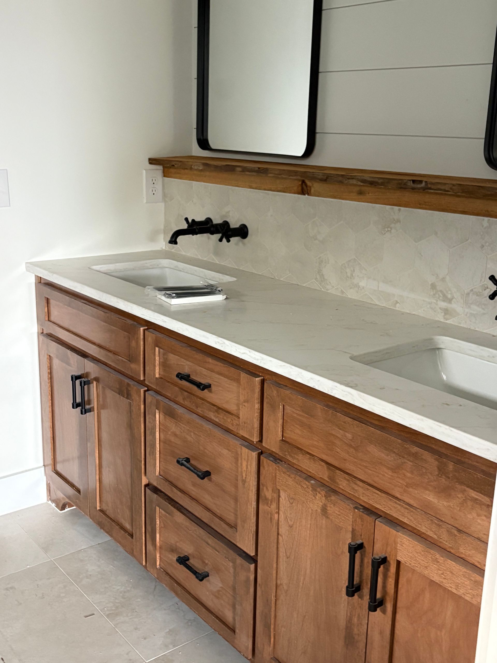 Brown kitchen cabinets with granite countertop and stainless steel sink.