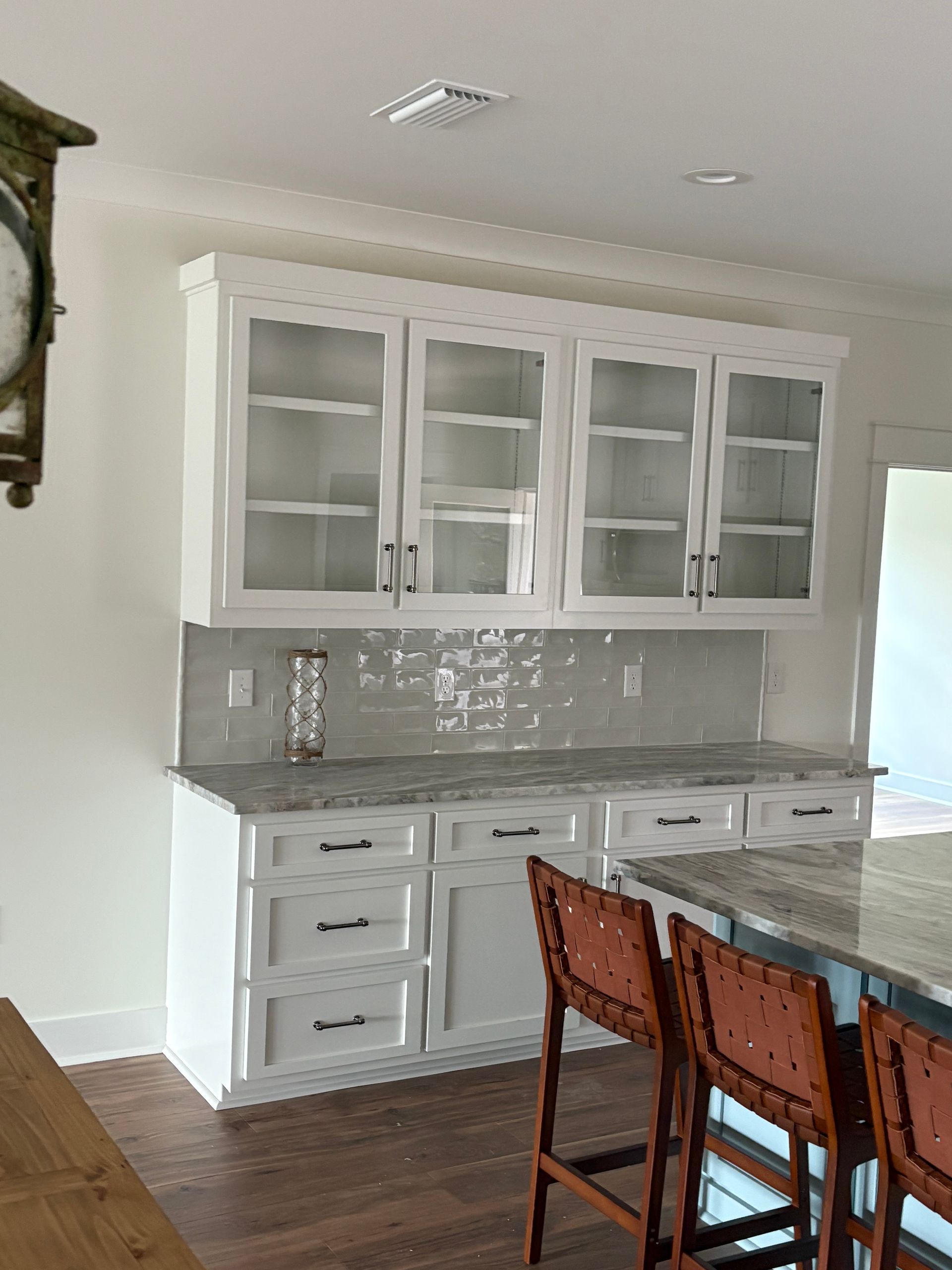 Wooden storage cabinets built under stairs; drawers and doors with silver handles.