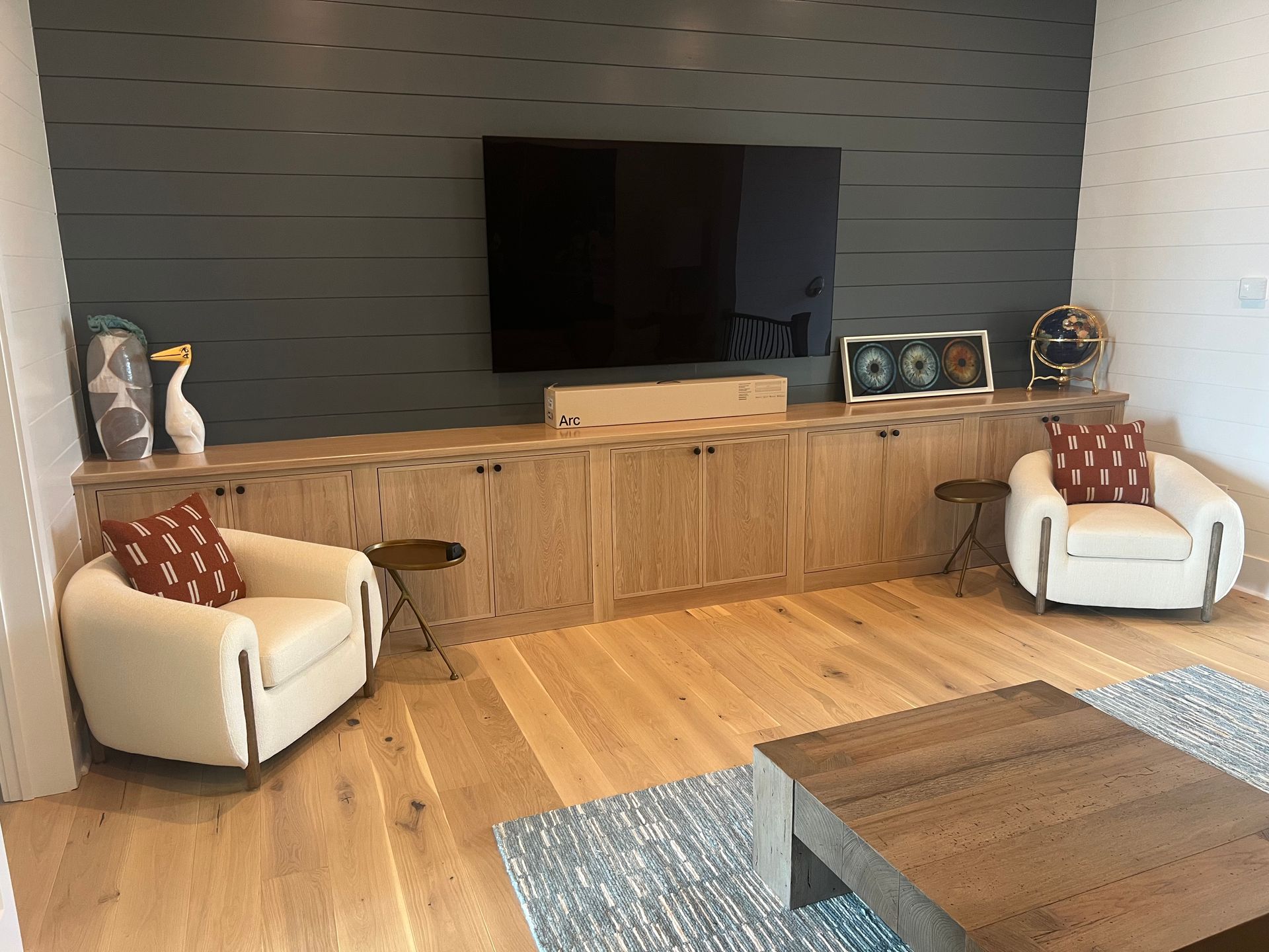 Spacious kitchen with a large gray island and stainless steel appliances; wood floors.