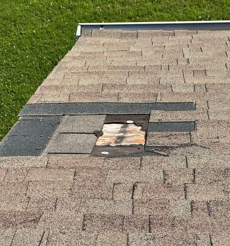 Storm-damaged residential roof in North Alabama showing displaced shingles after a severe weather event - QRE Construction storm damage repair service.