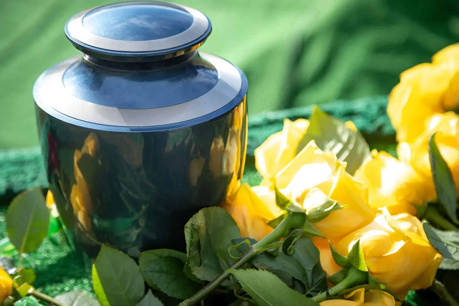 Blue and silver cremation urn with yellow roses.