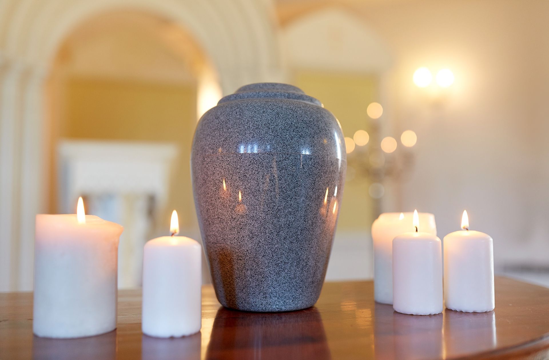 Urn and candles on a table, memorial setting.