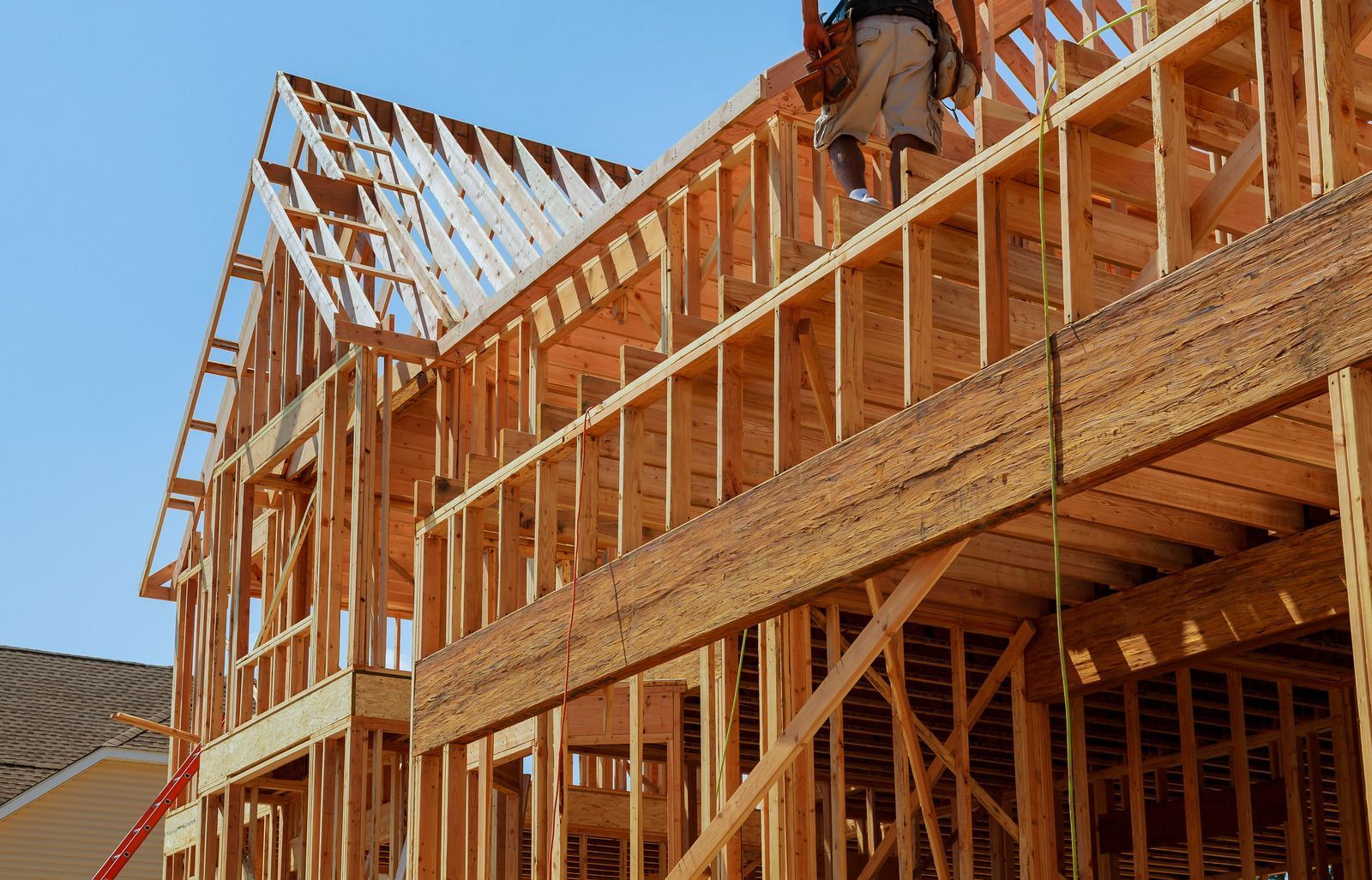 A man is standing in front of a house under construction.