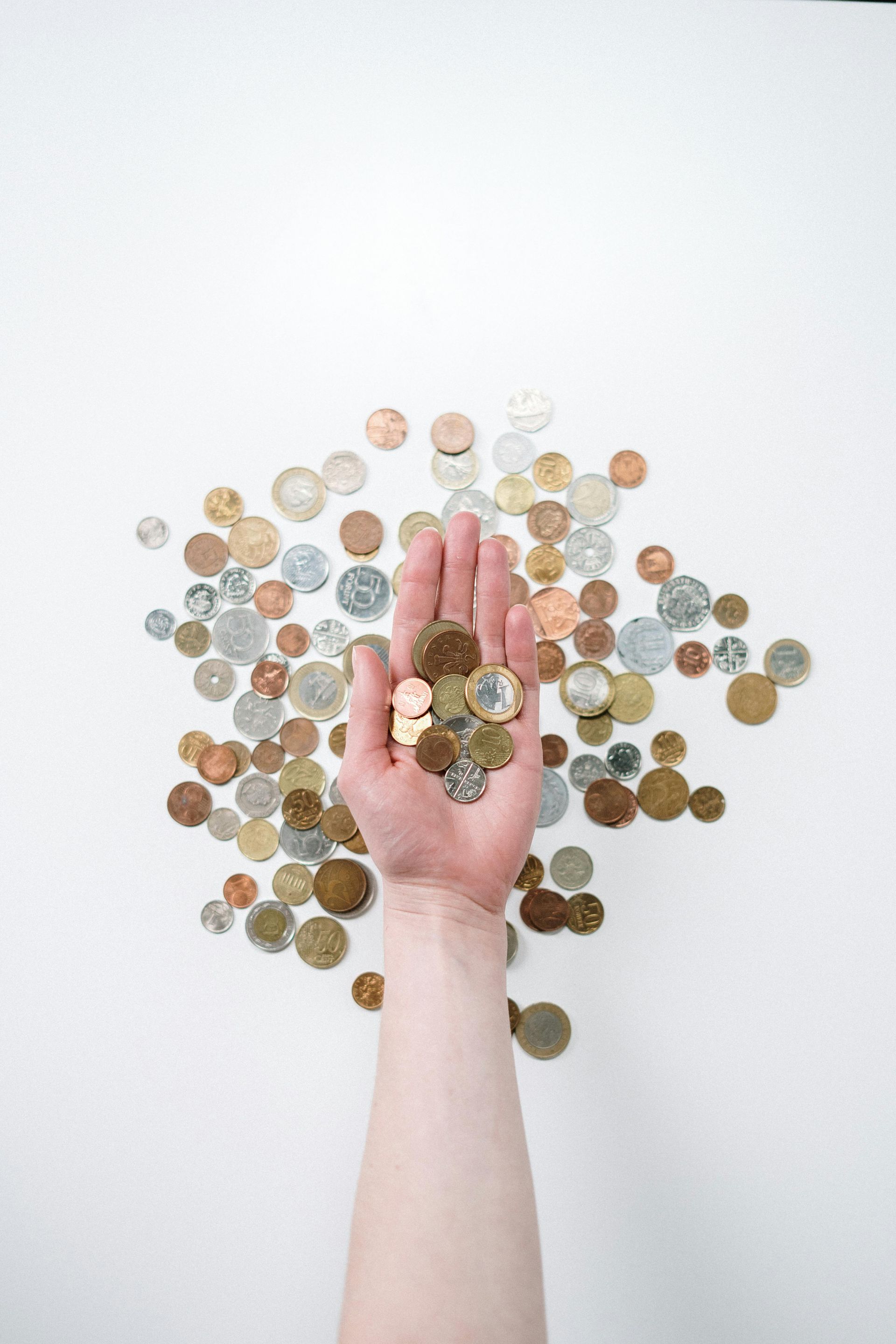 A person is holding a pile of coins in their hand.