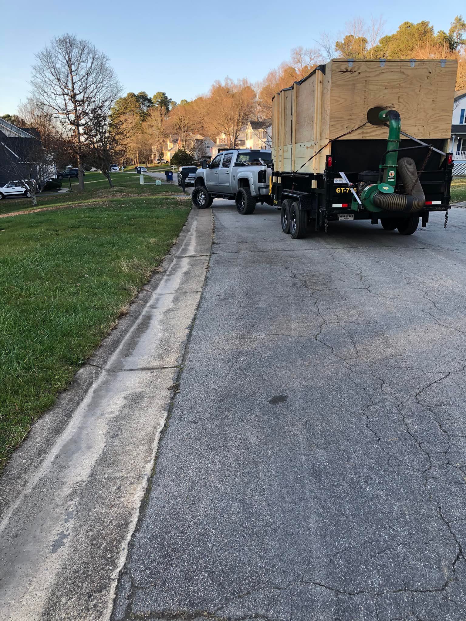 A truck with a trailer attached to it is parked on the side of the road.