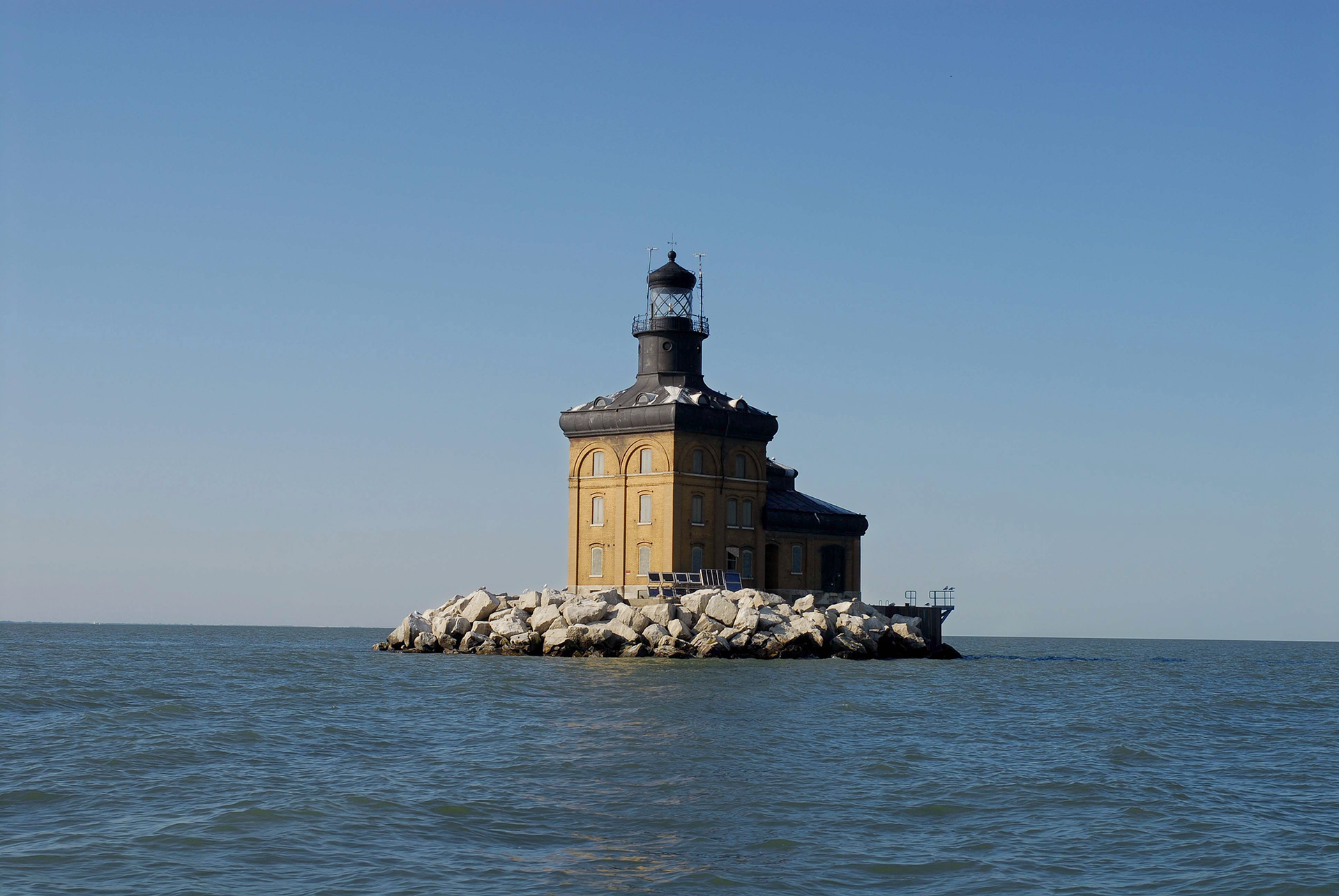 a lighthouse on a small island in the middle of the ocean