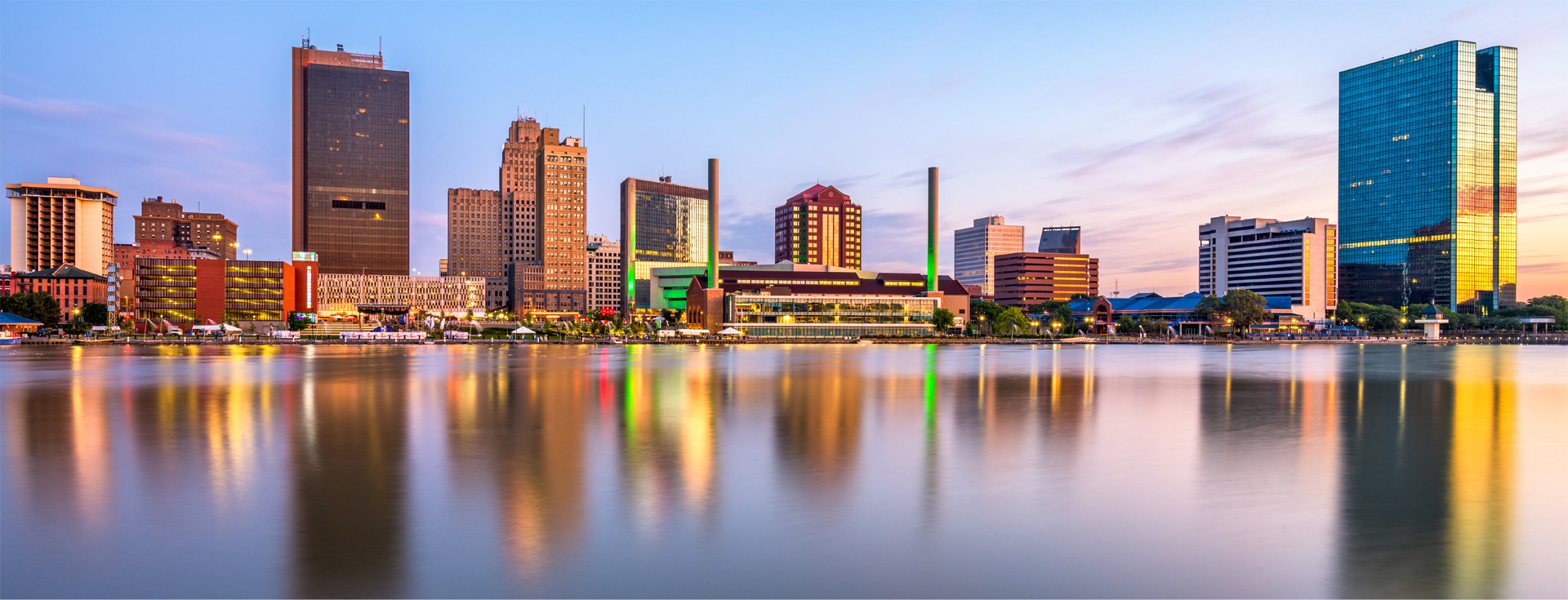 a city skyline is reflected in a body of water .
