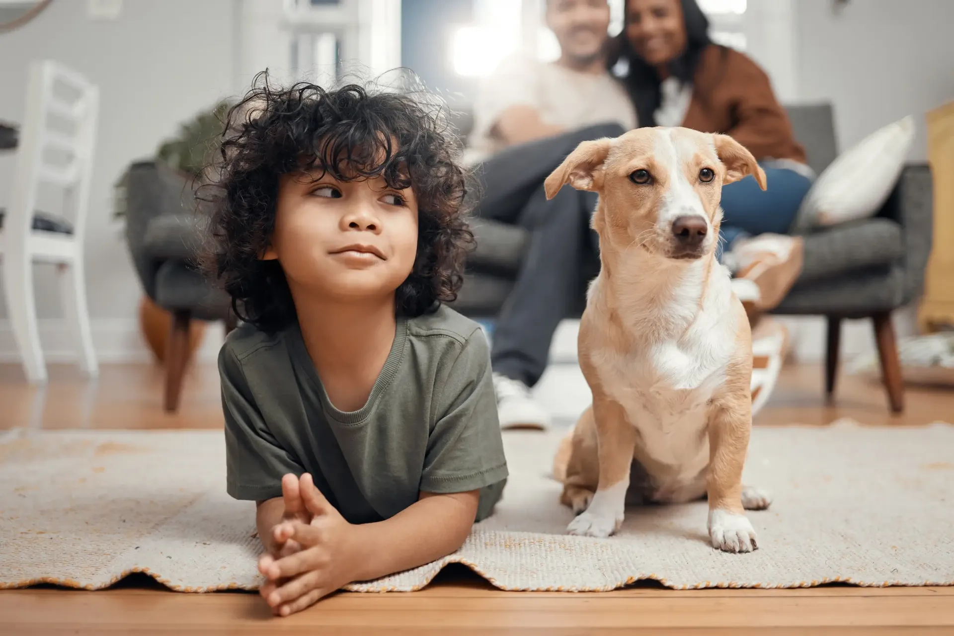 Boy and dog laying on rug.
