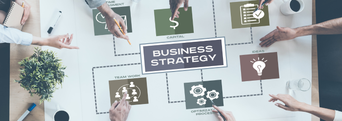 Personas colaborando en un diagrama de estrategia empresarial. Manos señalando iconos alrededor de un rectángulo central que dice