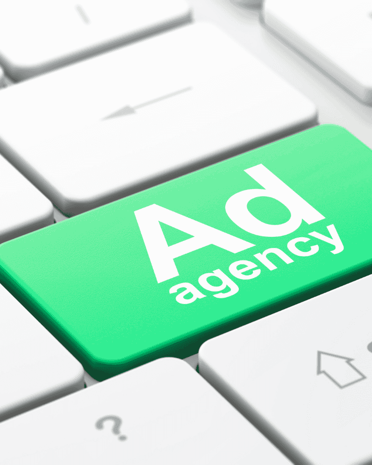 Una tecla verde en un teclado que dice agencia de publicidad
