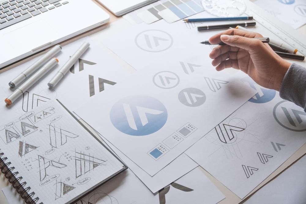 A Person Is Drawing a Logo on A Piece of Paper — Signmax Bundaberg In Kensington, QLD