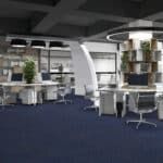 Modern open office with white desks, blue carpet, shelving, and a curved support column