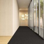 Modern hallway with black carpet, wood-paneled wall, glass windows, and abstract wall lights