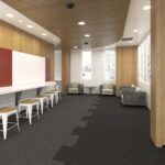 Modern office lounge with long white table, chairs, gray sofa, wood walls, and carpeted floor.