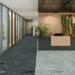 Modern lobby with glass walls, indoor plants, and a light wood reception desk