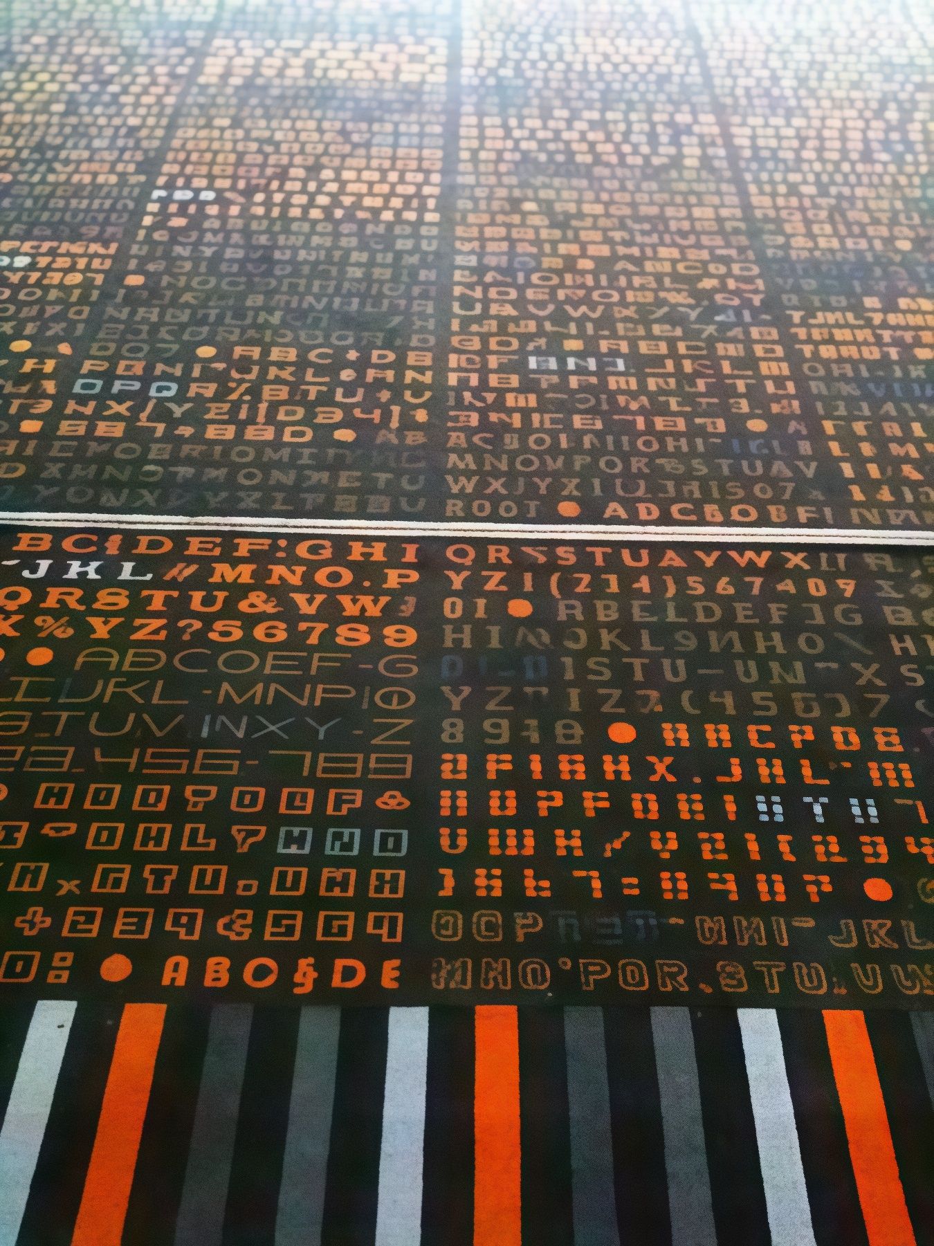 Glowing orange alphanumeric characters arranged in dense rows and columns on a dark surface