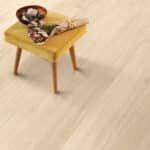 Small wooden side table with a bowl and a cloth on a light wood floor
