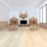 Bright classroom with light wood floors, small tables, and a wall mural featuring cartoon fox faces.