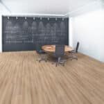 Modern conference room with chalkboard wall, round table, chairs, and wood flooring