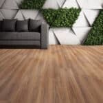 Modern living room with gray sofa, wooden floor, and geometric wall with green plants
