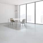 Minimal white office with a desk and two chairs by floor-to-ceiling windows.