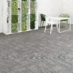 Gray textured flooring in a bright room with white table, chairs, and green plants by the wall