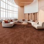 Modern lounge with curved cream sofas, round tables, wood-paneled walls, and a large grid window.