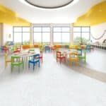 Bright classroom with colorful chairs, tables, large windows, and a curved yellow ceiling.